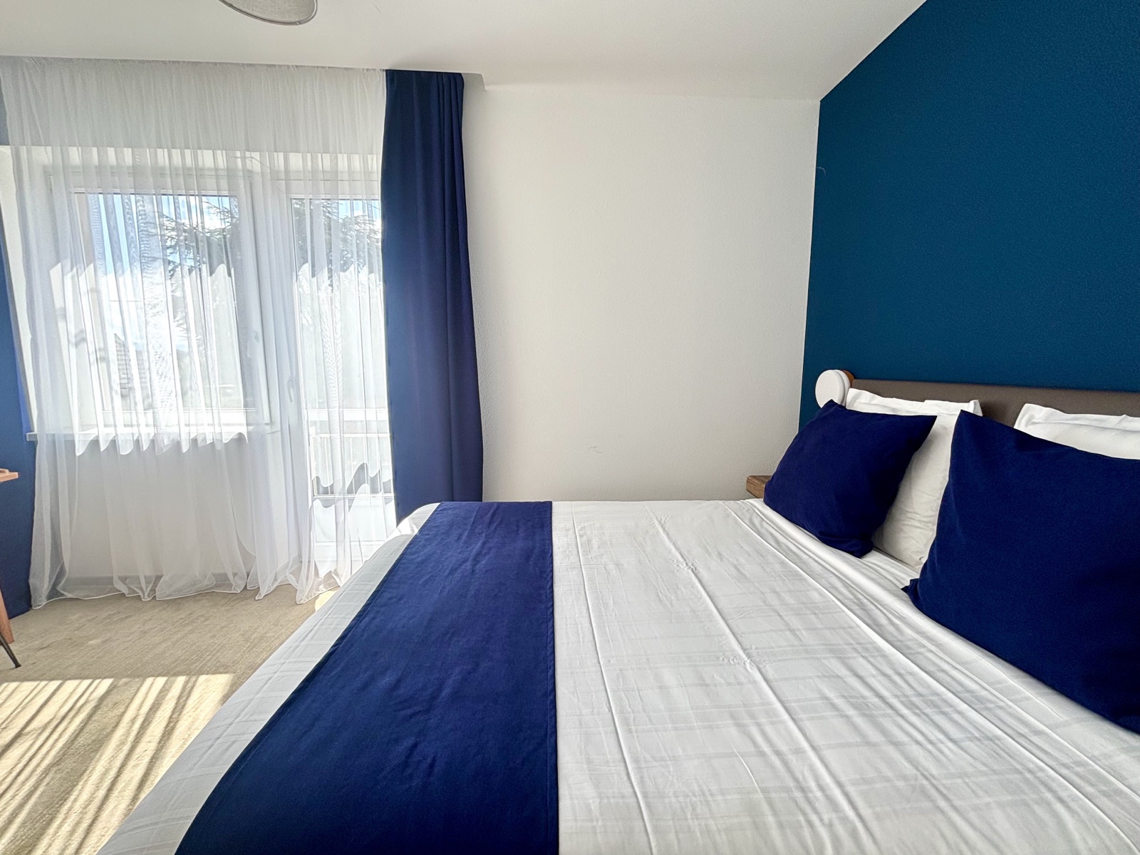 Chambre double au mur bleu nuit avec balcon — Hôtel du Village